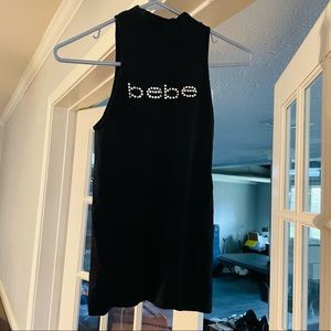 Bebe, black stretch sleeves, mock turtleneck , logo rhinestone top, with cut out